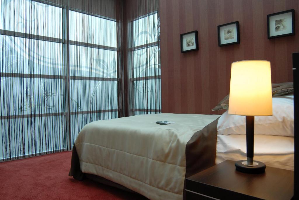 a hotel room with a bed and a large window at Hotel Pik in Mikołów