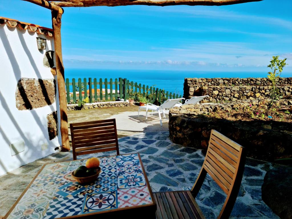 d'une terrasse avec une table et deux chaises et l'océan. dans l'établissement VV Casa Bastina "by henrypole home", à Mazo