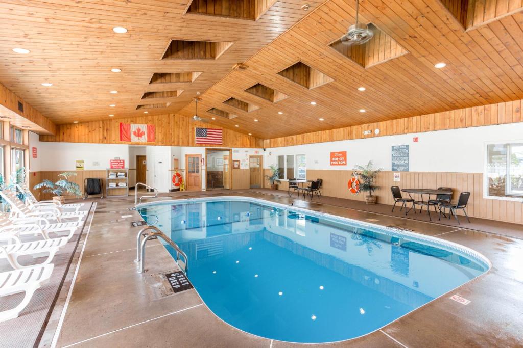 a swimming pool in a building with a wooden ceiling at Quality Inn & Suites in Plattsburgh