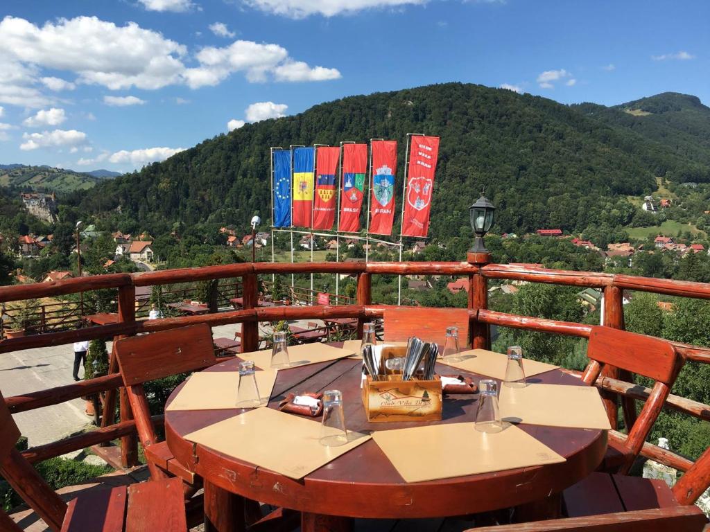 a table on a balcony with a view of a mountain at Club Vila Bran in Bran