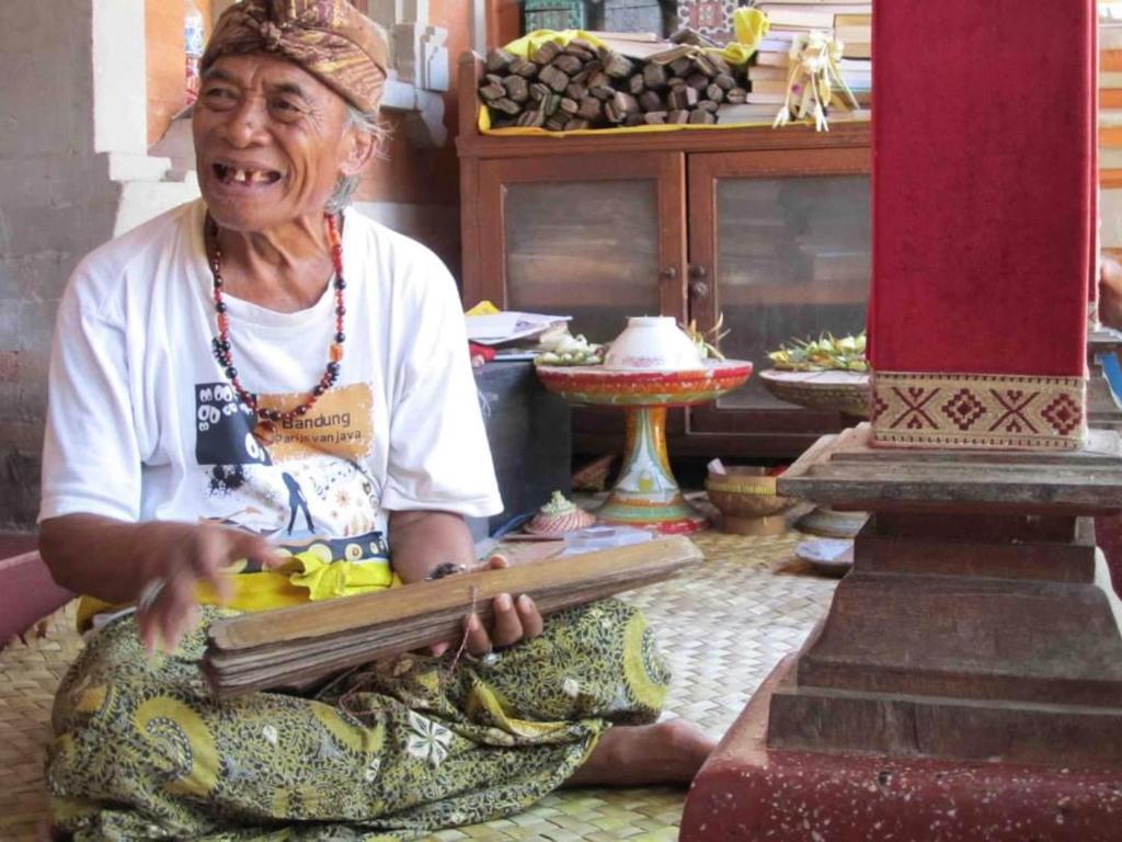 a woman sitting on the floor with a large snake at Liyer Spirit House in Ubud
