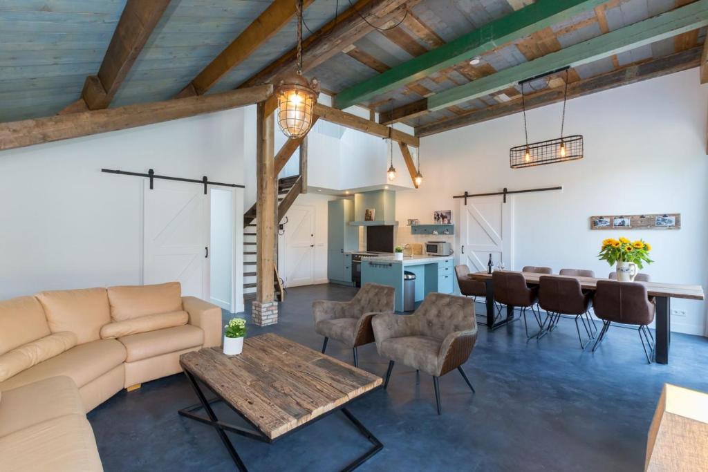 ein Wohnzimmer mit einem Sofa und einem Tisch in der Unterkunft Holidayhouse - Lepelstraat 18A Vrouwenpolder 't Blauwtje in Vrouwenpolder