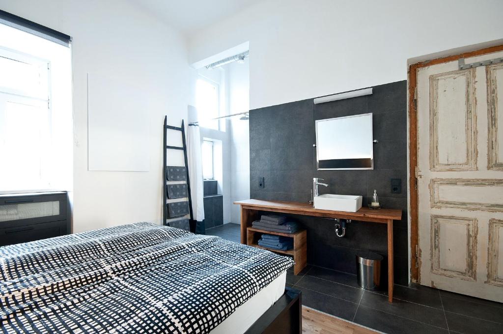 a bedroom with a bed and a sink and a mirror at Zentrales & modernes City-Apartment in Graz