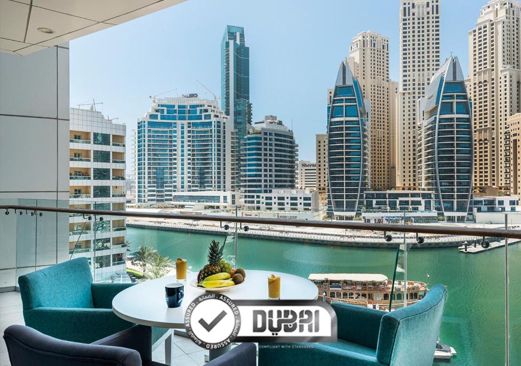 a table and chairs with a view of a city skyline at Jannah Marina Hotel Apartments in Dubai