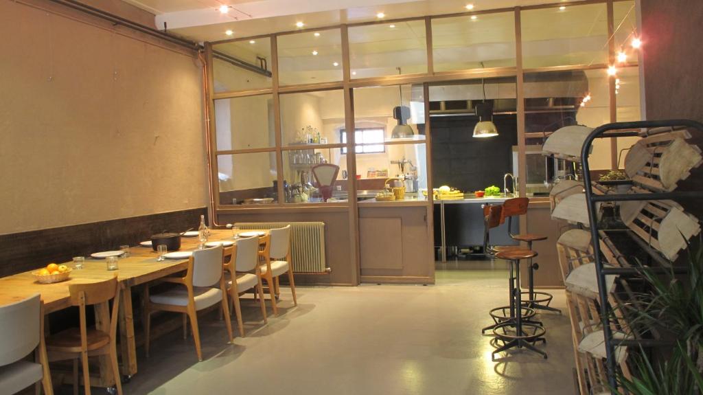 a restaurant with a table and chairs and a kitchen at Chambres d'hôtes L'Epicurium in Le Puy en Velay