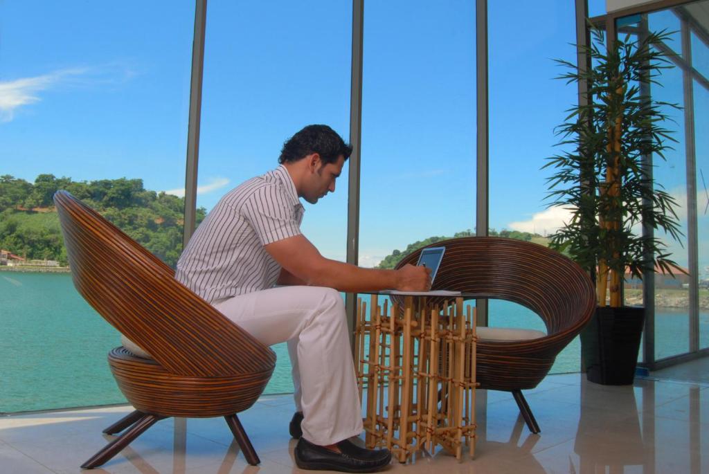 a man sitting at a table with a laptop at The Beach House in Panama City