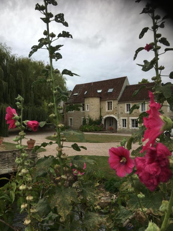 une maison avec des fleurs roses devant elle dans l'établissement Canon, Coeur De Combray, à Ernes