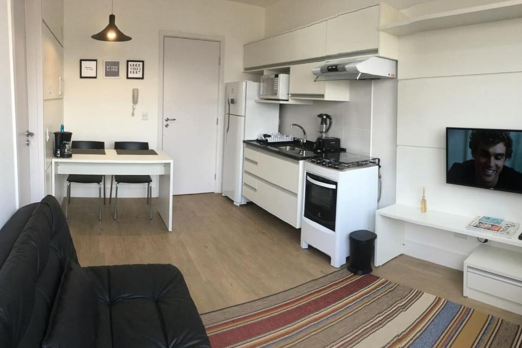a small kitchen with a table and a stove top oven at 609-Apartamento Decorado Encantador, mobiliado, amplo com 1 vaga de garagem, excelente localização no Rebouças in Curitiba