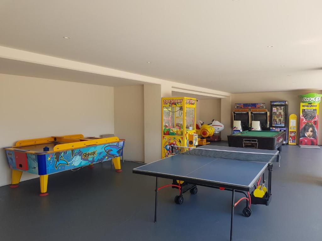a room with a ping pong table and other games at Nissiana Hotel & Bungalows in Ayia Napa