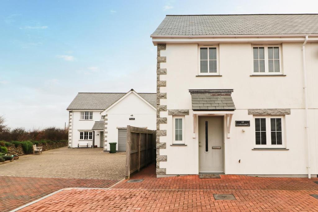 a white house with a brick driveway at NEAR BEACHES, contemporary home in village centre in St Merryn