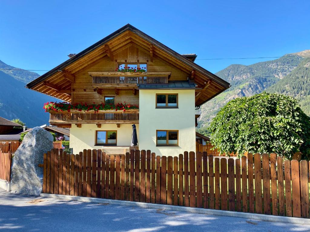 a house with a wooden fence in front of it at Ferienhaus Tirol im Ötztal in Umhausen