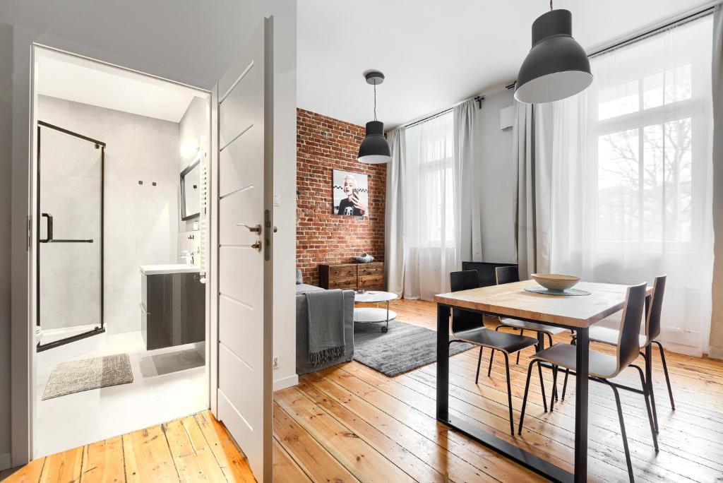 a dining room and living room with a table and chairs at MARGI Igram - Martini - Absynth Apartments LARGE & COMFY in Szczecin