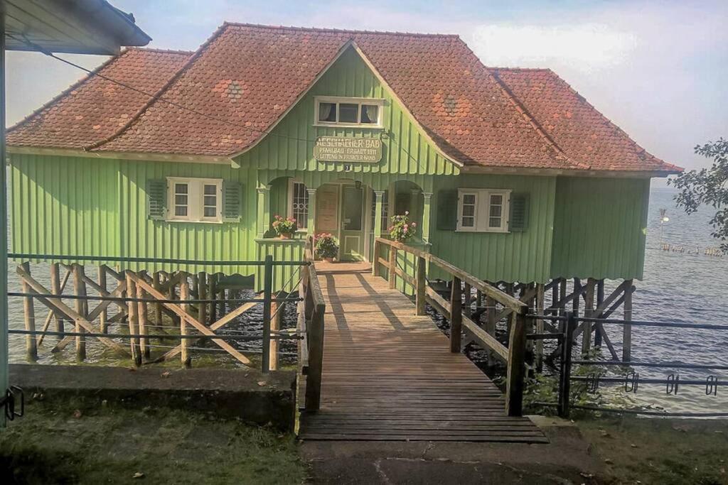 una casa verde en un muelle sobre el agua en Toni en Lindau