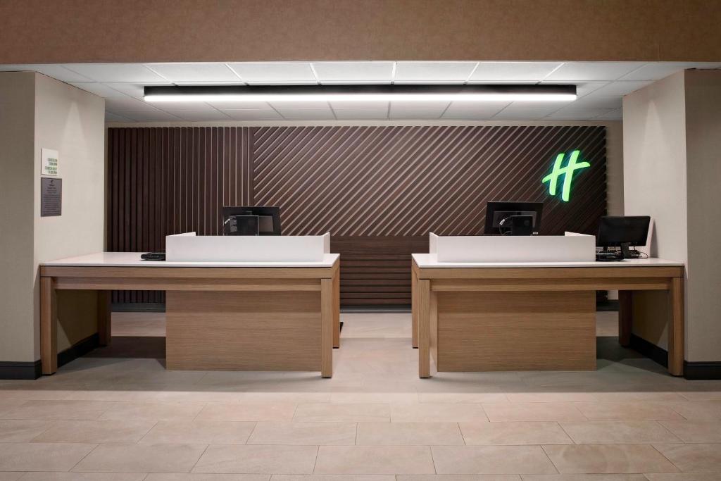 a lobby with two desks and a cross on the wall at Holiday Inn & Suites Boston Peabody, an IHG Hotel in Peabody