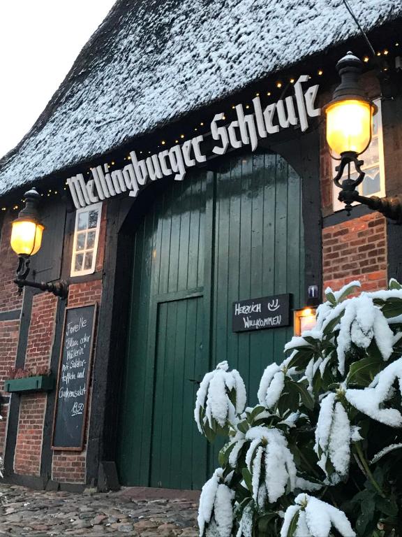 een gebouw met een groene deur met sneeuw erop bij Kleinhuis Hotel Mellingburger Schleuse in Hamburg