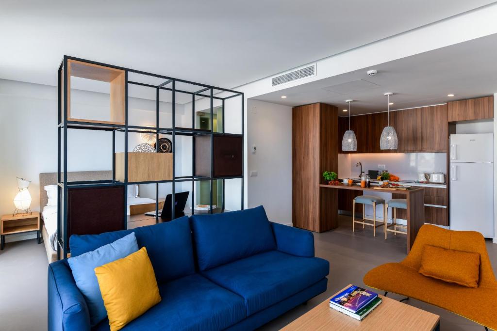 a living room with a blue couch and a kitchen at Oscar Concept Apartments in Lisbon