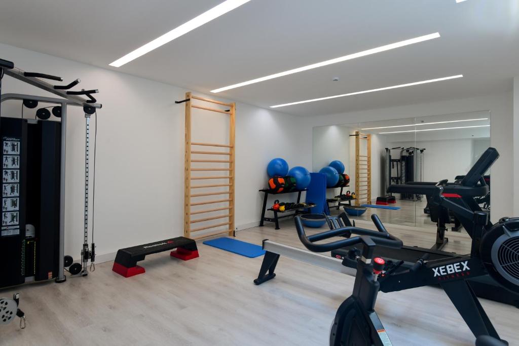 A mirrored fitness room equipped for cardio, strength, and functional exercise.