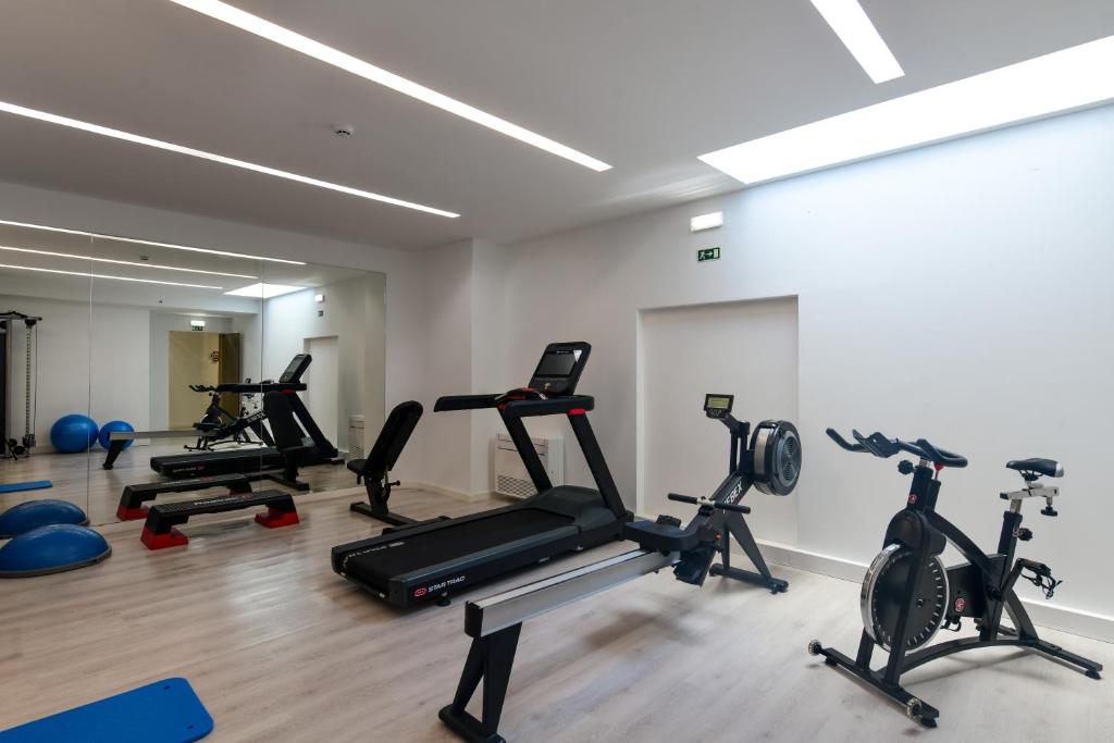 A bright gym with treadmills, exercise bikes and free weights.