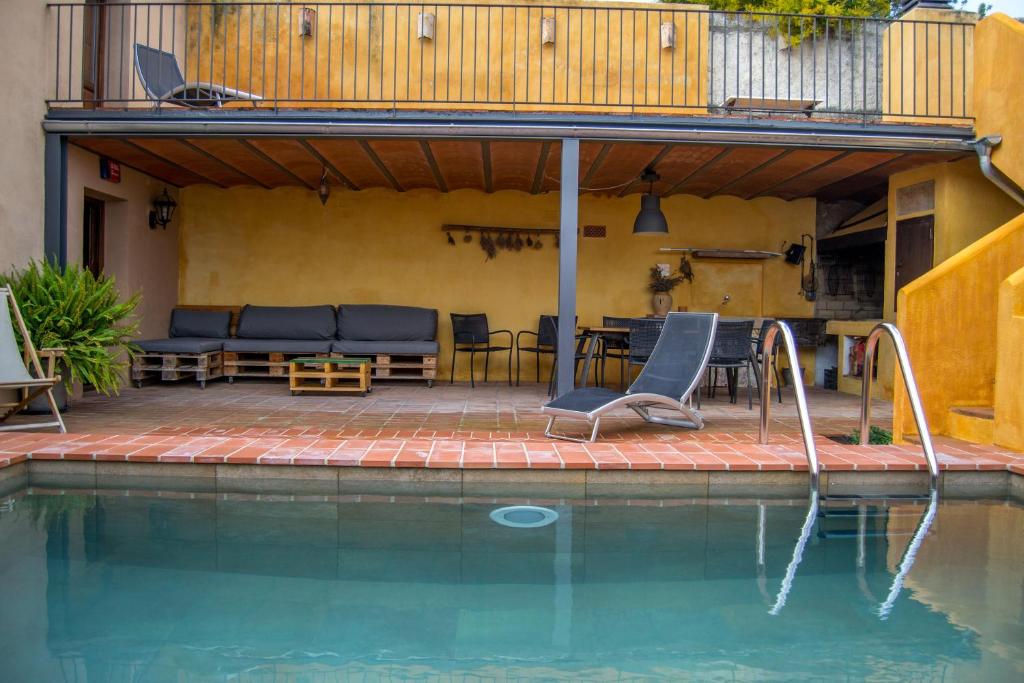 eine Terrasse mit einem Pool mit Stühlen und einem Tisch in der Unterkunft Els Cups casa rural in Sant Vicenç de Calders