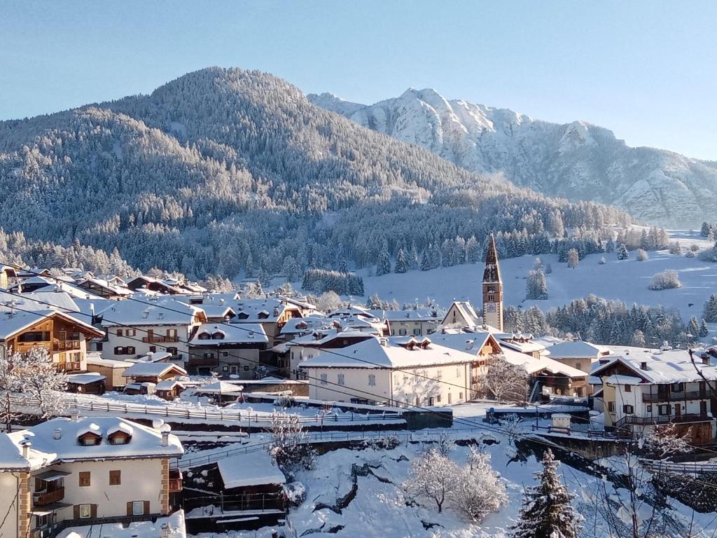 una città ricoperta di neve con un lago e montagne di Luigi Apartment a Varena