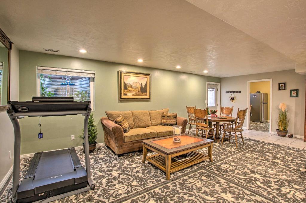 a living room with a couch and a table at Farr West Apartment on Farm Less Than 25 Mi to Ski Resorts 