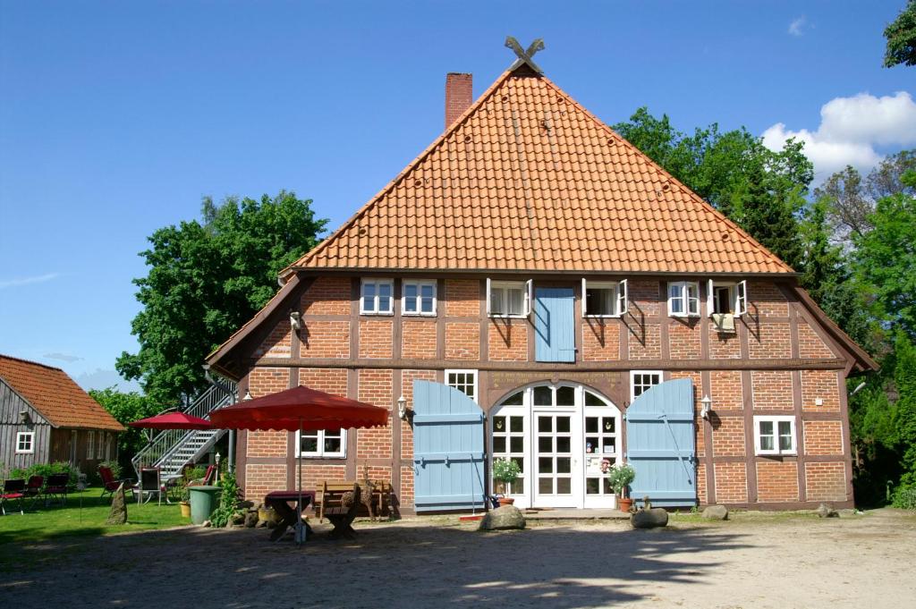 ein großes rotes Backsteingebäude mit rotem Dach in der Unterkunft Hotel TraumzeitHof in Eschede