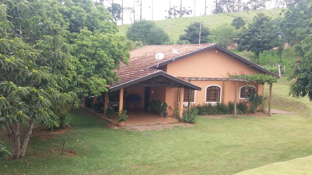 ein kleines Haus auf einem Feld mit Hof in der Unterkunft Sítio entre Santo Antonio Pinhal e Campos do Jordão in Santo Antônio do Pinhal