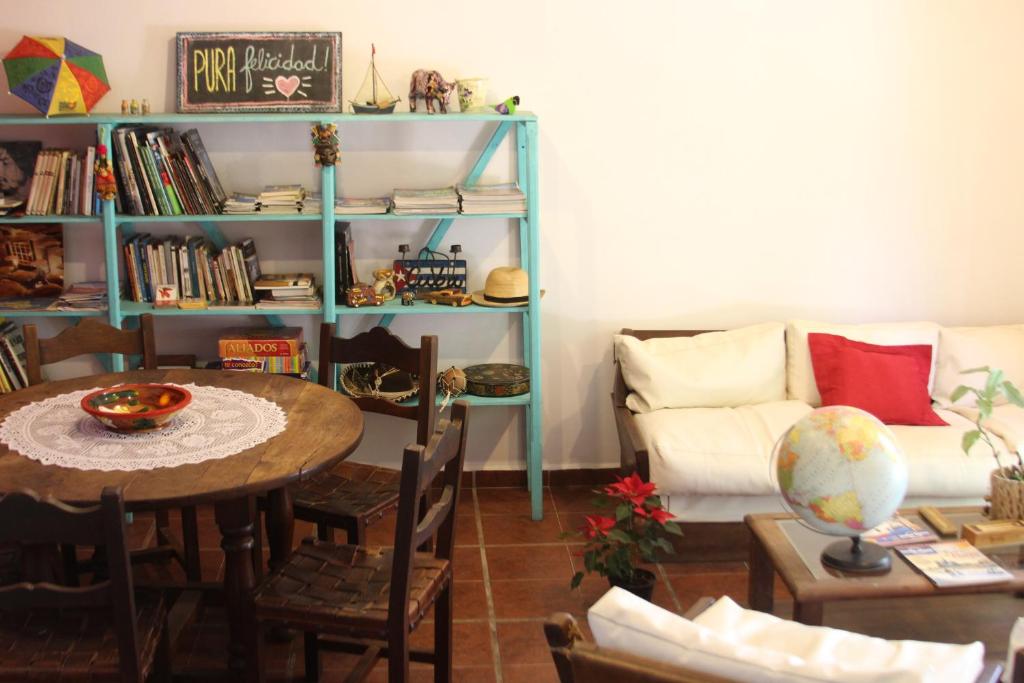 sala de estar con mesa y sofá en Pura Felicidad - Casa de viajeros en Alta Gracia