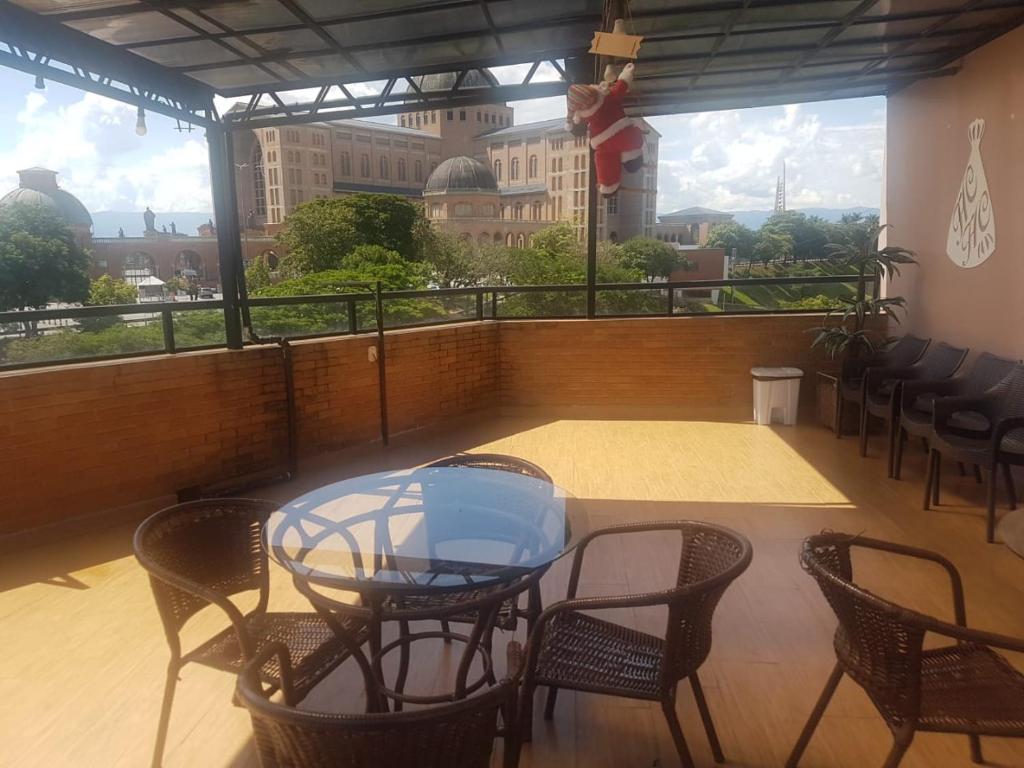 a table and chairs on a balcony with a view of a building at Hotel Colorado in Aparecida