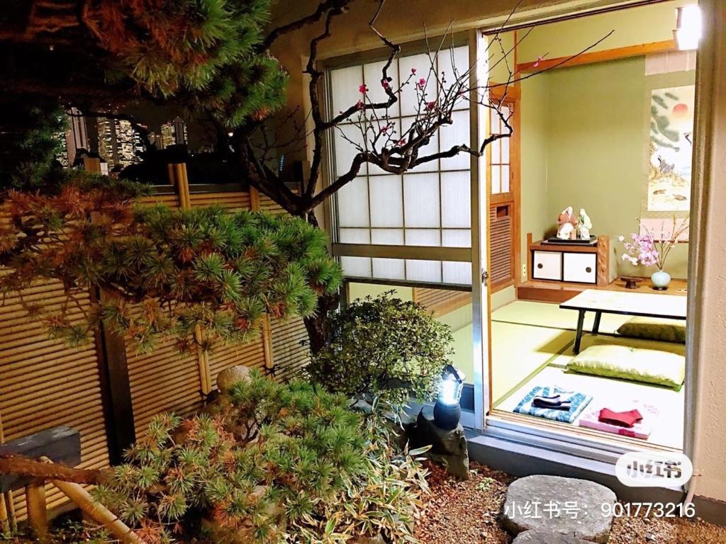 Elle offre une vue sur un jardin avec une table et quelques plantes. dans l'établissement Orient Corp 301 - Vacation STAY 10390, à Tokyo