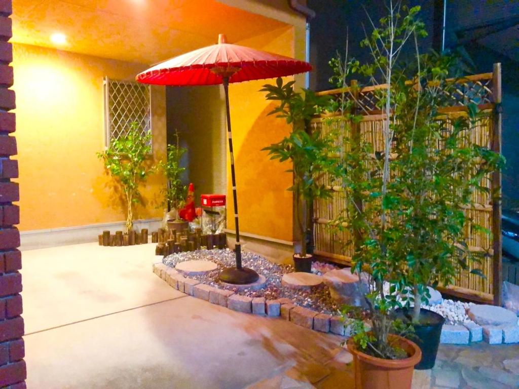 a patio with a red umbrella and some plants at Japanese style villa - Vacation STAY 10392 in Tokyo