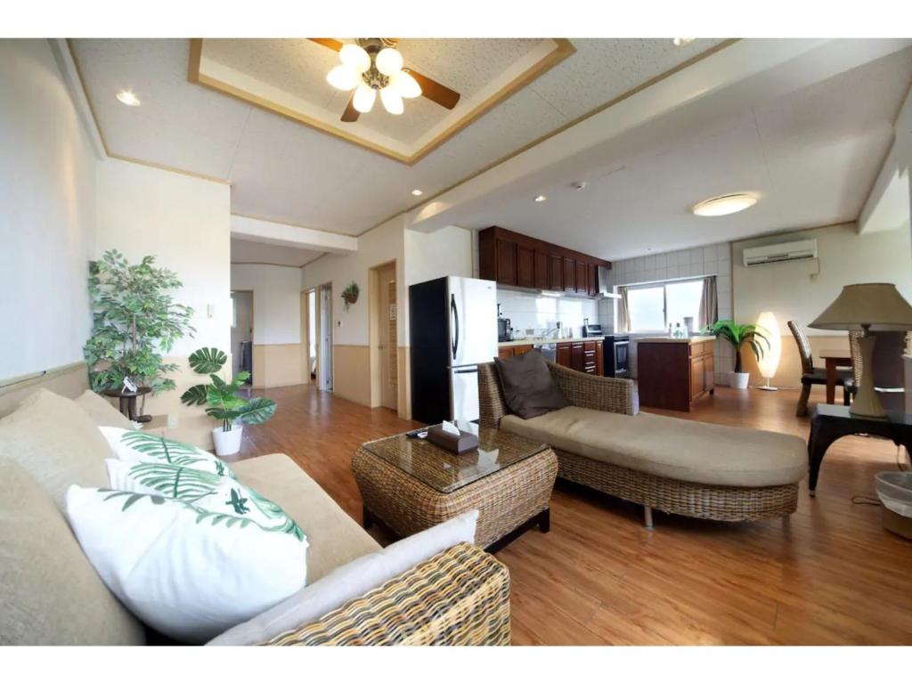 ein Wohnzimmer mit 2 Sofas und einer Küche in der Unterkunft Green Garden Hills 3F-1 - Vacation STAY 15233v in Okinawa