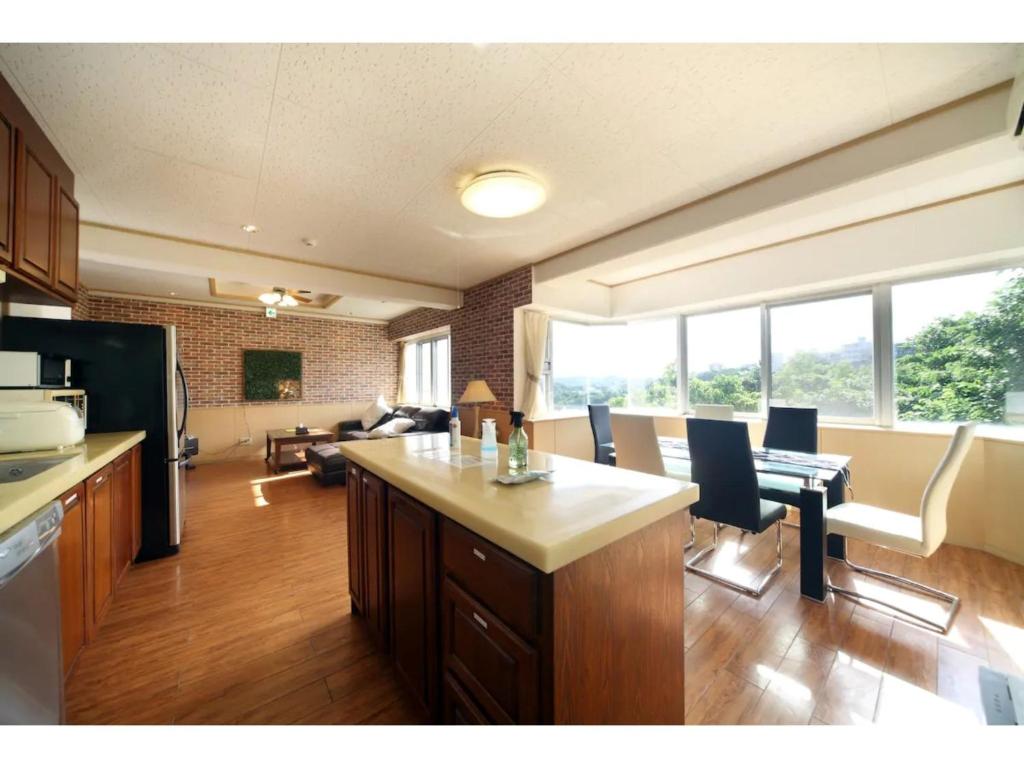 cocina y sala de estar con mesa y sillas en Green Garden Hills 3F-2 - Vacation STAY 15235v, en Okinawa City