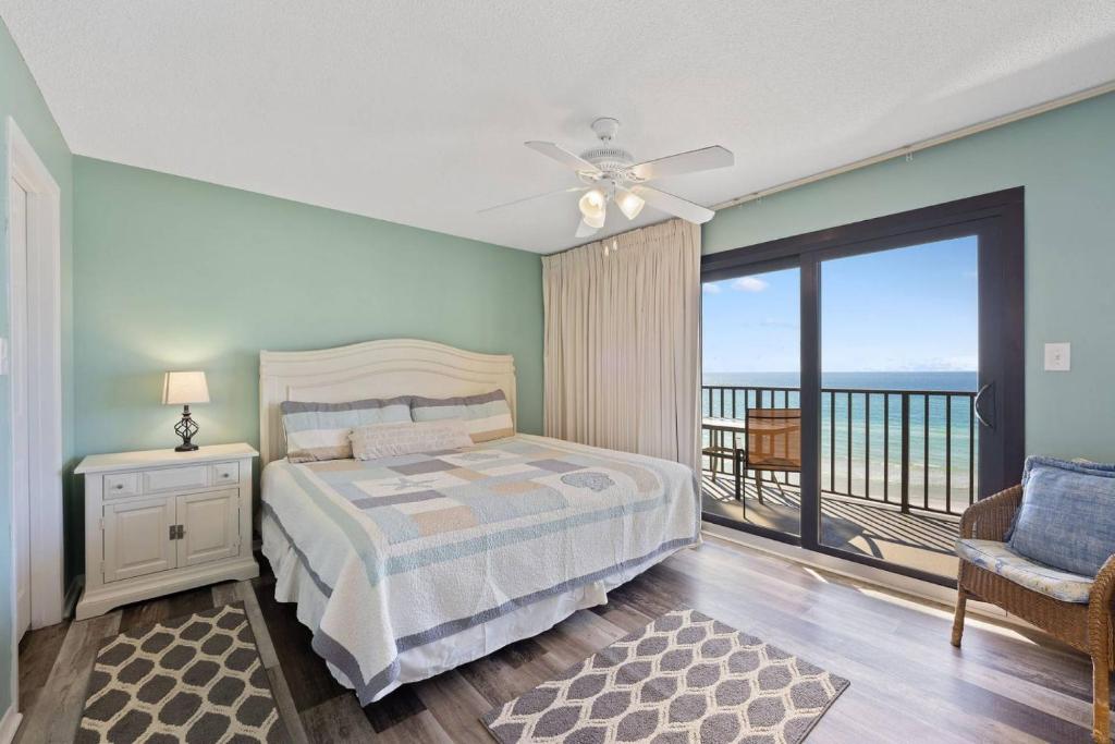 a bedroom with a bed and a balcony at Commodore 504 in Panama City Beach