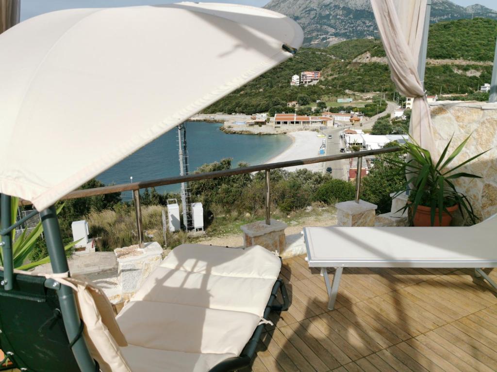 a balcony with a table and a white umbrella at Apartment Carpe Diem 1 in Utjeha