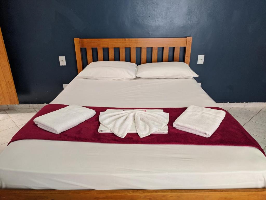 a bed with two white towels on top of it at Pousada Vila Appia in Cabo Frio