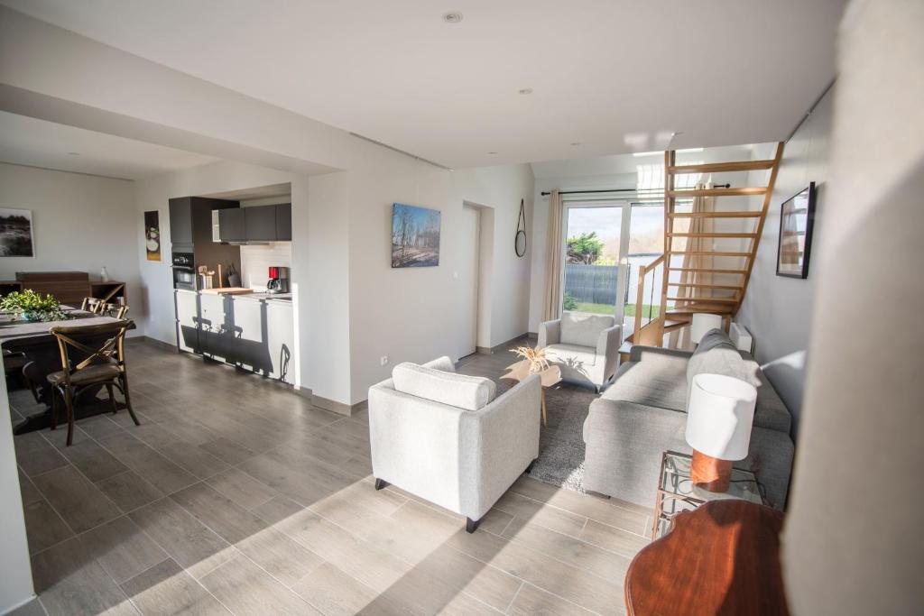 een woonkamer met een bank en een tafel bij Salicorne Villa rénovée à l'orée de la zone naturelle in Groffliers