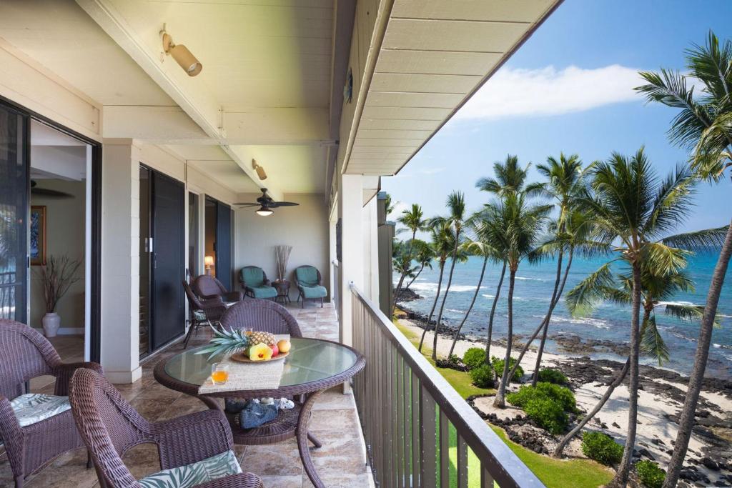 d'un balcon avec une table et des chaises donnant sur l'océan. dans l'établissement Kona Bali Kai #419 by Casago Kona, à Kailua-Kona