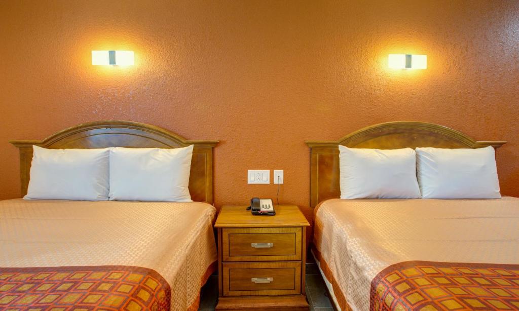 a hotel room with two beds and a night stand at Motel 6 Branson, Mo in Branson