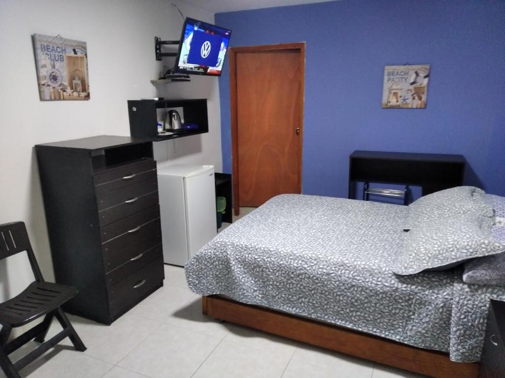 1 dormitorio con 1 cama, vestidor y TV en Kings House, en San Andrés