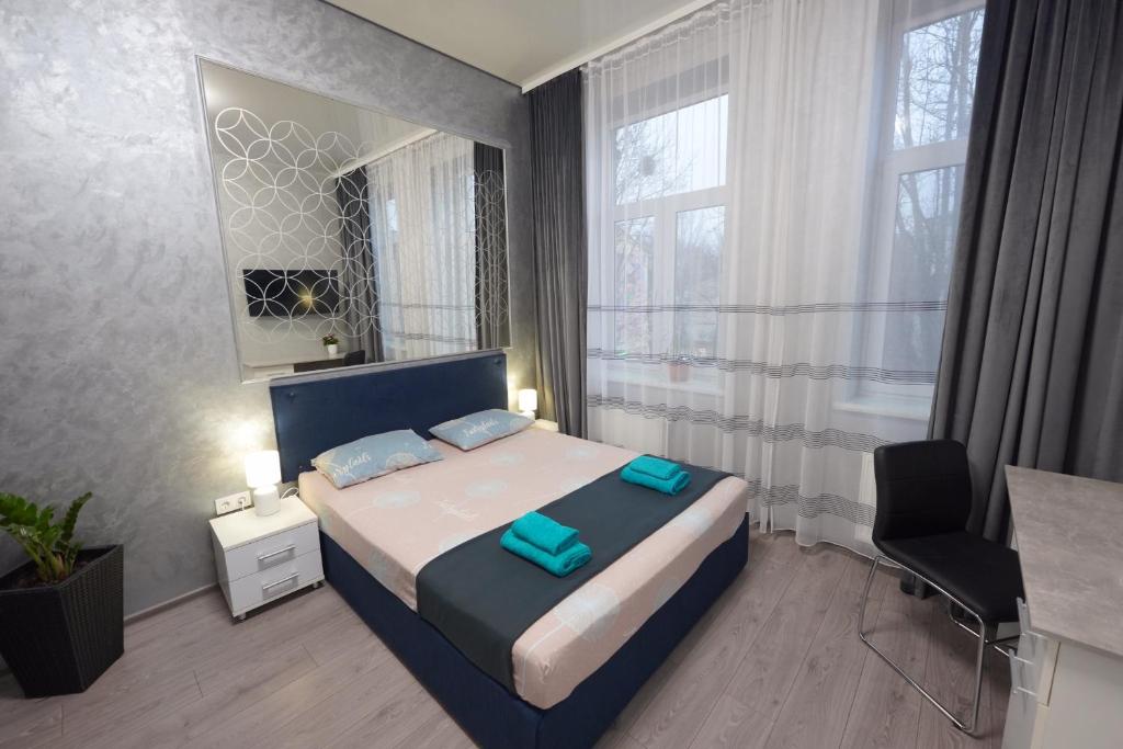 een slaapkamer met een bed, een bureau en een raam bij New cozy apartment near Opera House and “Malevich” in Lviv