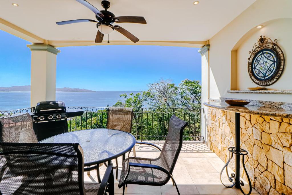 un patio con mesa, sillas y el océano en Oceanica 804 en Playa Flamingo