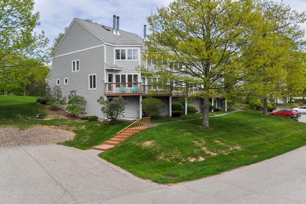 Una gran casa blanca con un árbol y una entrada. en 37 Partridge Woods, en Bartlett