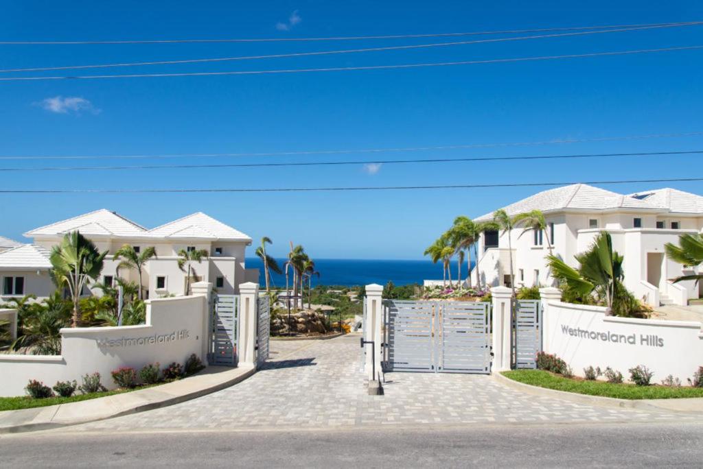 a gate to a villa with the ocean in the background at 26 Westmoreland Hills - Mount Standfast - St James in Saint James