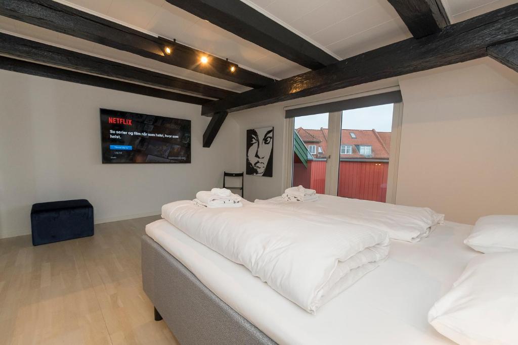 1 dormitorio con 2 camas blancas y ventana en Modern Luxury Penthouse en Sønderborg