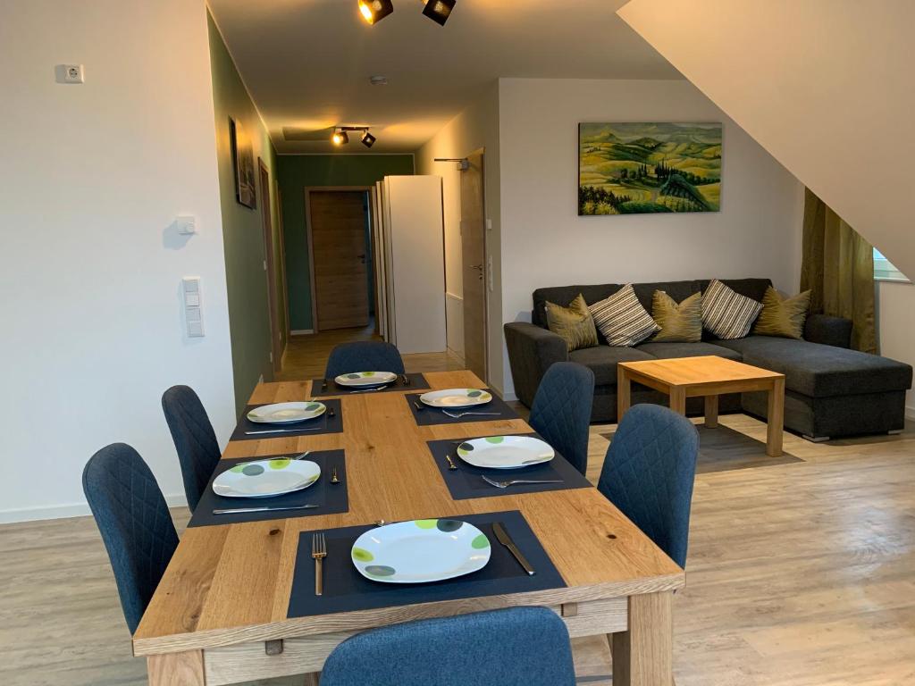 sala de estar con mesa de madera y sillas en Niwas Apartments, en Fulda