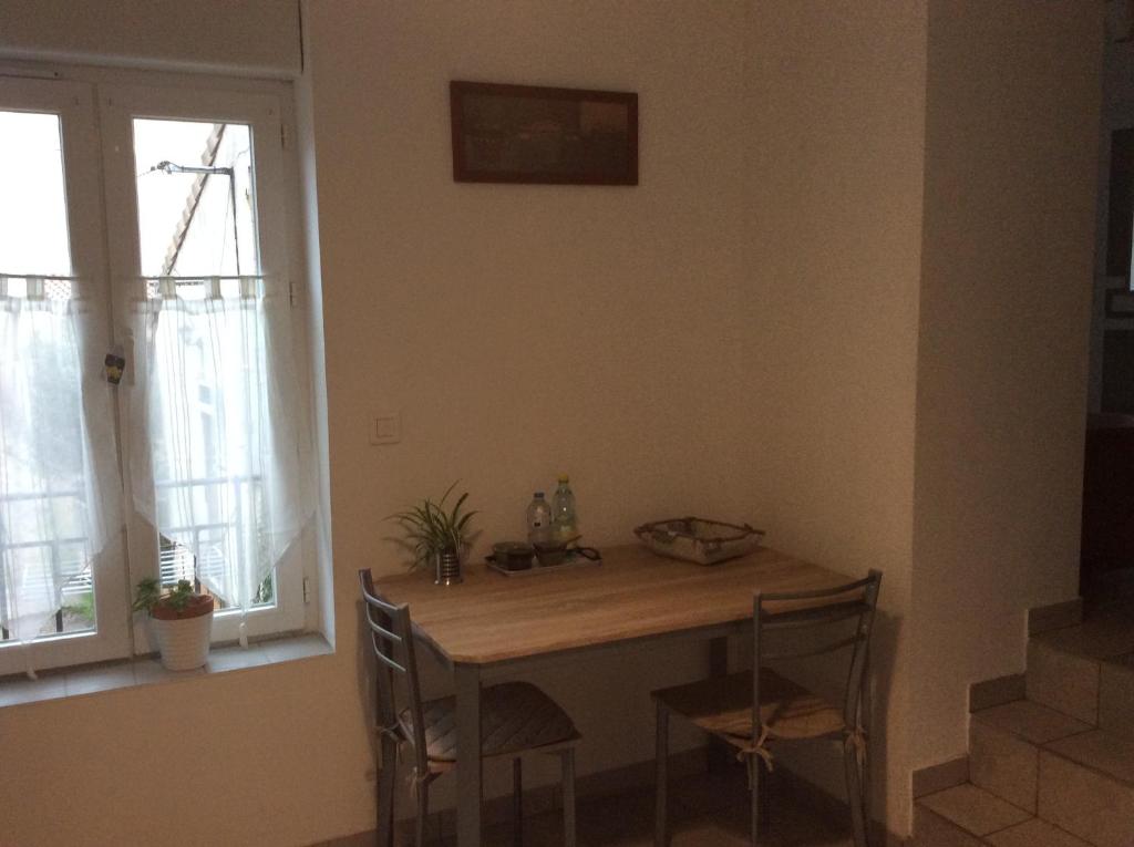 einen Tisch und Stühle in einem Zimmer mit Fenster in der Unterkunft Studio confortable 33 m2 in Hérépian