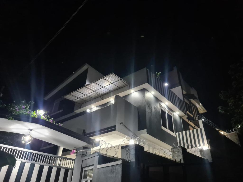 Una casa de noche con luces encendidas. en Edville residence, en Kampala