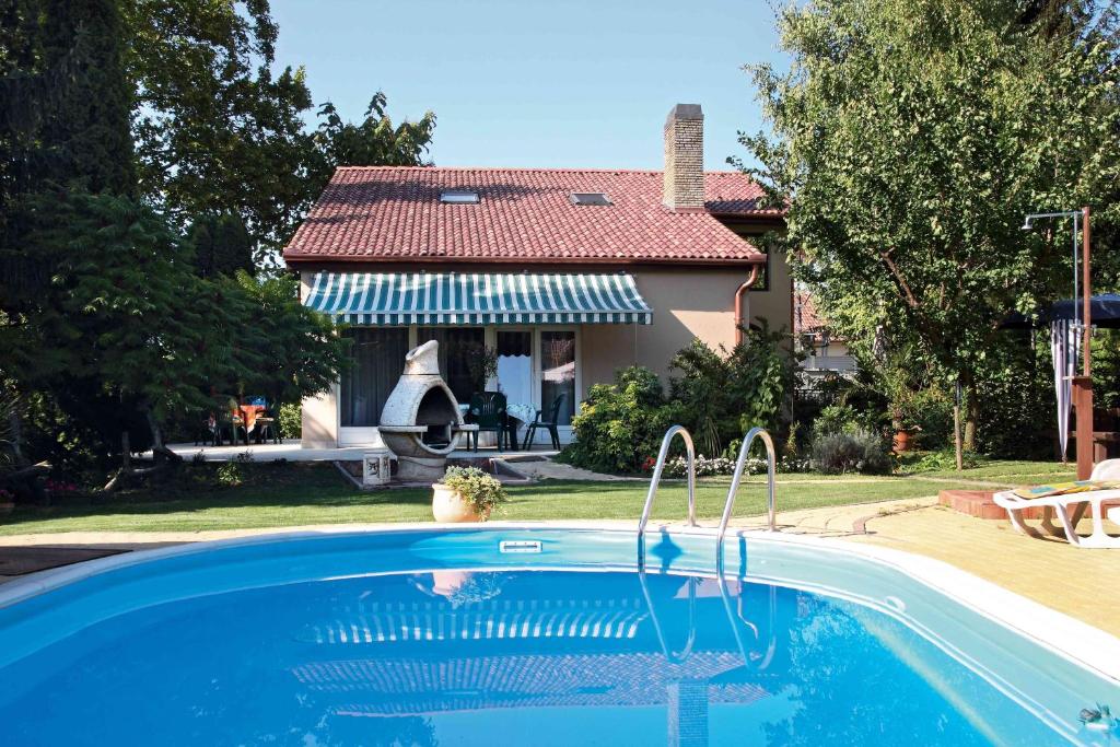 a house with a swimming pool in front of a house at Aba Wellness House in Balatonszárszó