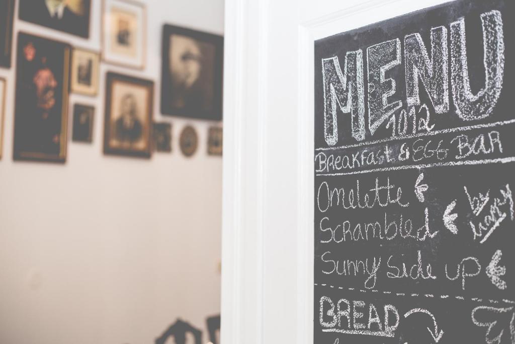a chalkboard sign with a menu on a wall with pictures at Sintra1012 Boutique Guesthouse in Sintra